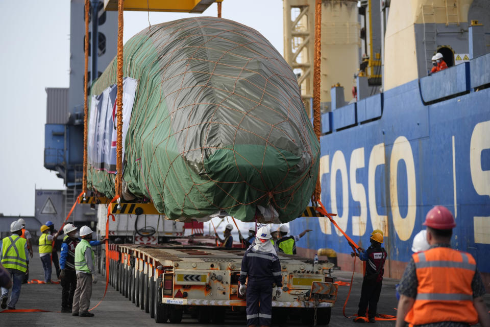 Workers position a part of Chinese-made high-speed passenger train onto a truck at Tanjung Priok Port in Jakarta, Indonesia, Friday, Sept. 2, 2022. The first high-speed electric train which is prepared for the Jakarta-Bandung High-Speed Railway arrived in the capital city on Friday.(AP Photo/Dita Alangkara)