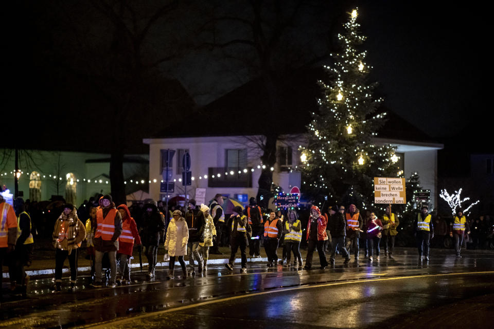 Opponents of the Corona measures walk at a demonstration near the church square in Koenigs Wusterhausen, Germany, Monday evening, Dec. 13, 2021. People have demonstrated against the Corona measures in several cities in Germany. (Fabian Sommer/dpa via AP)