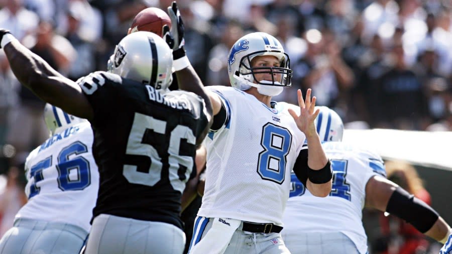 Jon Kitna throws a pass in front of an Oakland Raider defender.