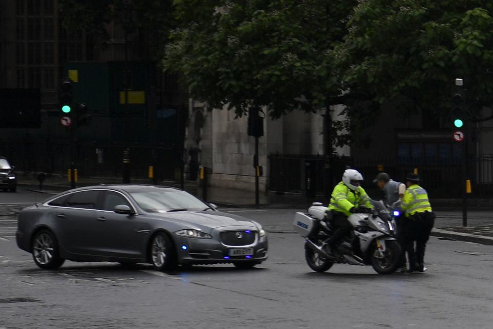 A protester from a pro-Kurdish demonstration is stopped and detained by police officers as he ran towards the car of Britain's Prime Minister Boris Johnson (L) as it was leaving with a police escort from the Houses of Parliament in London on June 17, 2020. - The protester ran into the road towards the Jaguar that normally carries the Prime Minister Boris Johnson and was stopped by police. As the Jaguar stopped it was subsequently struck from behind by the next vehicle in the convoy resulting in a large dent. (Photo by DANIEL LEAL-OLIVAS / AFP) (Photo by DANIEL LEAL-OLIVAS/AFP via Getty Images)