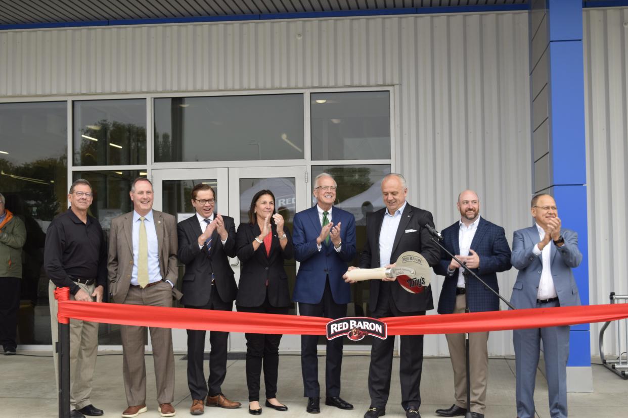 Joined by several dignitaries including Salina Mayor Mike Hoppock, U.S. Rep. Tracey Mann, Kansas Lt. Gov. David Toland and U.S. Sen. Jerry Moran, Dimitrios Smyrnios, CEO of Schwan's Company, holds an oversized pizza cutter which he used to cut a ribbon to celebrate the completion of a 400,000-square-foot expansion of the Schwan's pizza facility in Salina. The facility is the largest frozen pizza plant in the world.