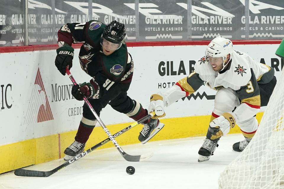 Arizona Coyotes center Drake Caggiula (91) passes the puck in front of Vegas Golden Knights defenseman Brayden McNabb (3) during the first period of an NHL hockey game Friday, Jan. 22, 2021, in Glendale, Ariz. (AP Photo/Ross D. Franklin)