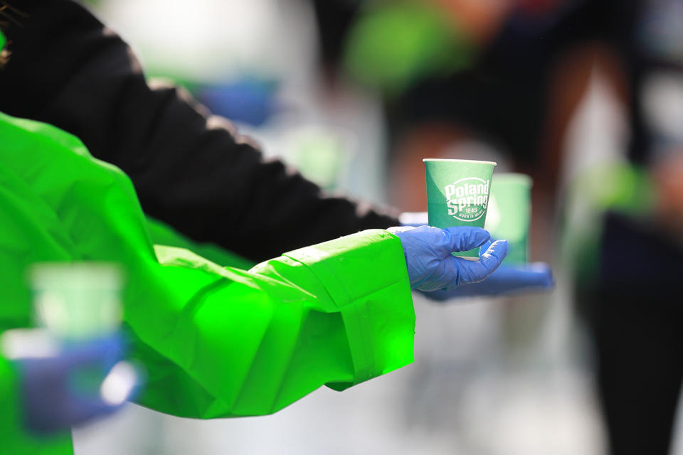 A volunteers holds out a cup of water during the 2019 New York City Marathon. (Photo: Gordon Donovan/Yahoo News)