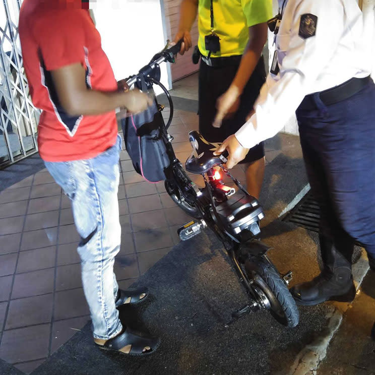 Authorities catching a rider for an unapproved power-assisted bicycle. (Photo: Facebook/LTA)