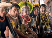 Indigenous tribesmen listen to chief Raoni Metuktire (out of frame) during a press conference in Piaracu village, near Sao Jose do Xingu, Mato Grosso state, Brazil