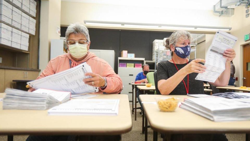 Rochelle Friedman, left, and Susan Gordon remove ballots from envelopes and count out stacks of 50 as counting resumed at the San Luis Obispo County Clerk-Recorder’s office on Tuesday, June 14, 2022.. Mail-in ballots require a multi-step process carried out by hand, including checking envelope signatures, making sure no red ink was used, and ensuring that there are no identifying marks on the ballot.