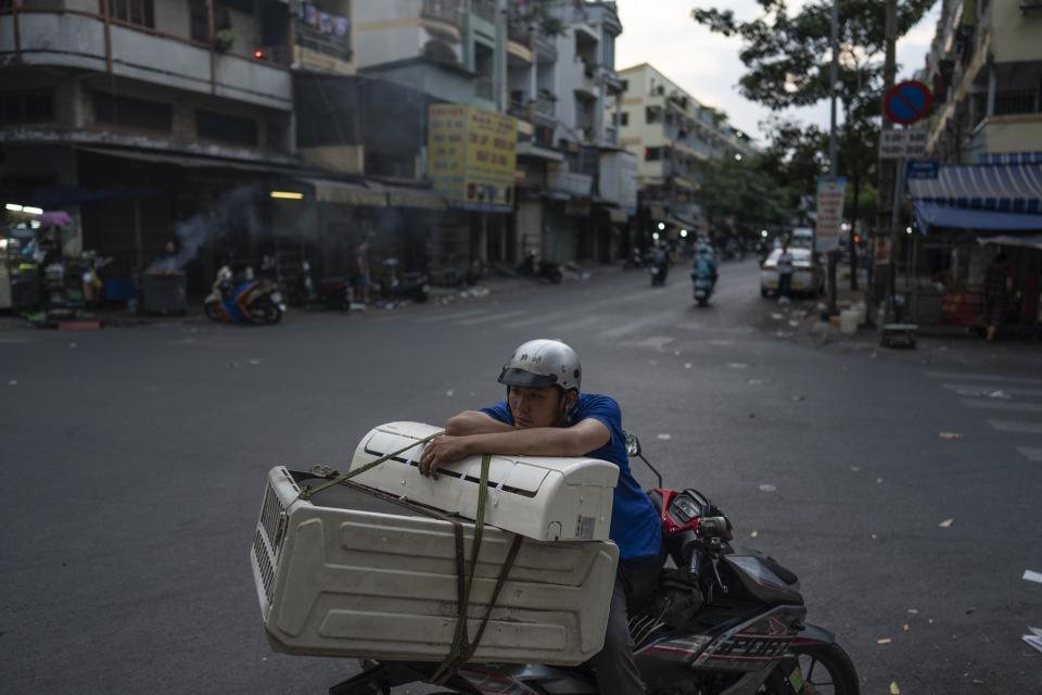 A man sits on a scooter with shells of home appliances loaded on the back of his bike in Nhat Tao market, the largest informal recycling market in Ho Chi Minh City, Vietnam, Monday, Jan. 29, 2024. (AP Photo/Jae C. Hong)