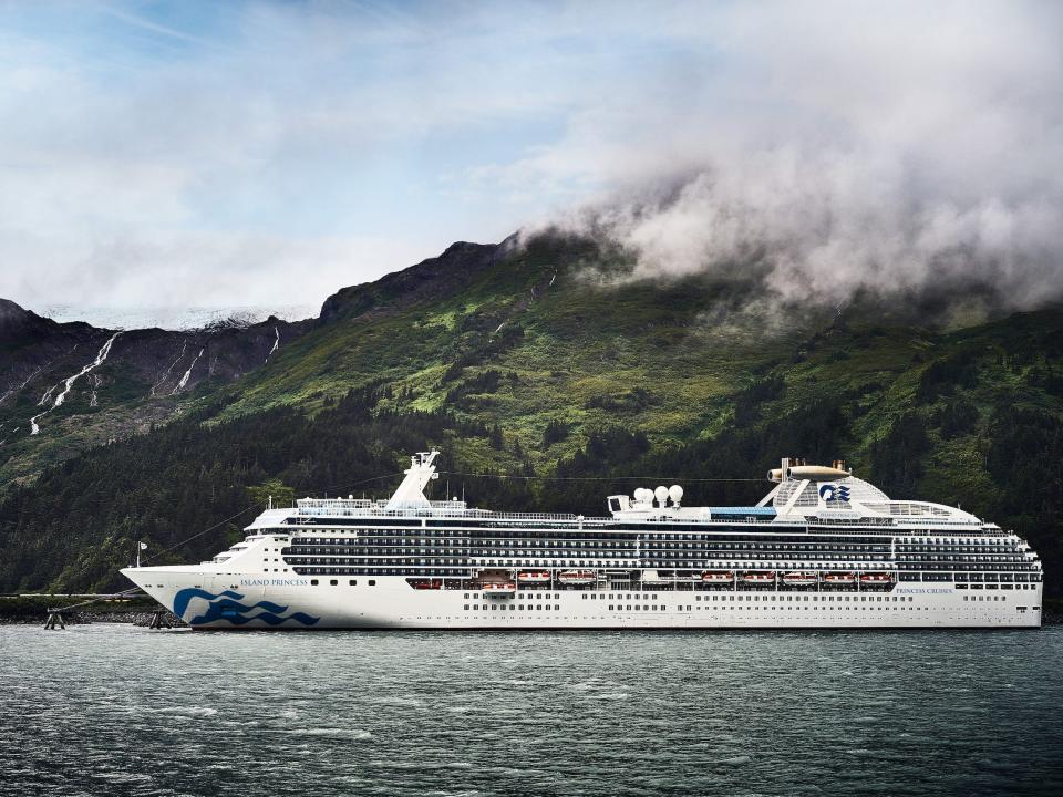 Princess Cruises' Island Princess cruise ship sailing past hills on a foggy day