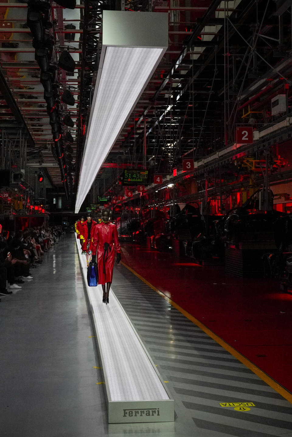 A model wears a creation as part of the Ferrari women's and men's Spring Summer 2022 collection, in Maranello, Italy, Sunday, June 13, 2021. (AP Photo/Antonio Calanni)