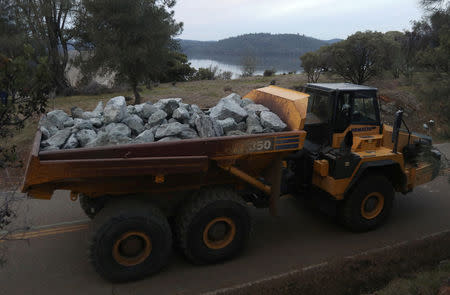 Rock is hauled to the Lake Oroville Dam after an evacuation was ordered for communities downstream from the dam in Oroville, California, U.S. February 13, 2017. REUTERS/Jim Urquhart