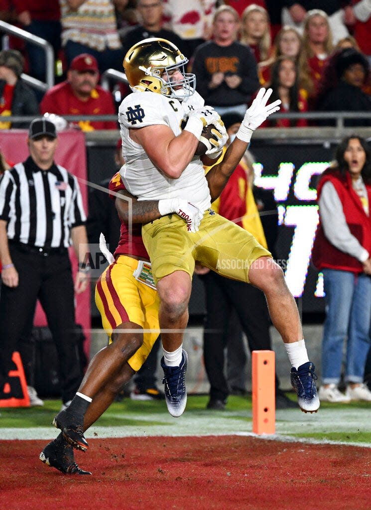 LOS ÁNGELES, CA - 26 DE NOVIEMBRE: El ala cerrada de Notre Dame Fighting Irish Michael Mayer (87) atrapa un pase para un touchdown frente al back defensivo de USC Trojans Max Williams (4) durante la primera mitad de un partido de fútbol americano universitario jugado el 26 de noviembre , 2022 en el Los Angeles Memorial Coliseum en Los Ángeles, CA.  (Foto de John Cordes/Icon Sportswire) (Icon Sportswire vía AP Images)