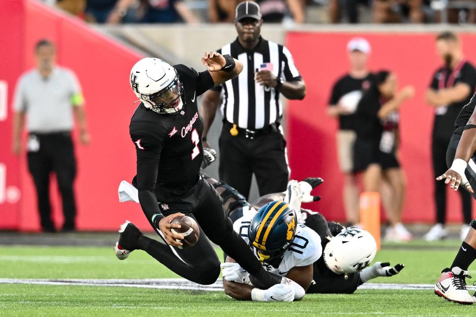 West Virginia linebacker Jared Bartlett (10) brings down Houston QB Donovan Smith (1). Bartlett is now a UC Bearcat.