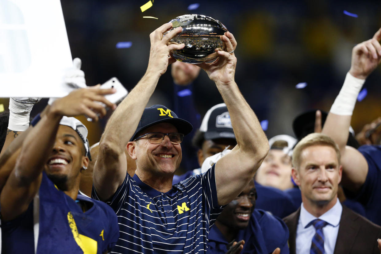 INDIANAPOLIS, IN - DECEMBER 03: Michigan Wolverines head coach Jim Harbaugh raises the Big Ten Championship trophy during the Big Ten Championship Game between the Michigan Wolverines and the Purdue Boilermaker on December 03,2022, at Lucas Oil Stadium in Indianapolis, IN.  (Photo by Jeffrey Brown/Icon Sportswire via Getty Images)