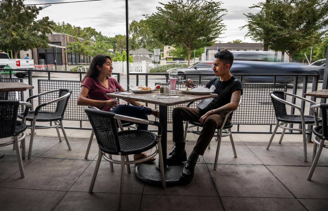 Victoria Blanco and Cesar Medina, both of Sacramento, have lunch at Burgers and Brew on Monday, August 1, 2022. The City of Sacramento has opened R Street to traffic after closing it during the pandemic to help local business.