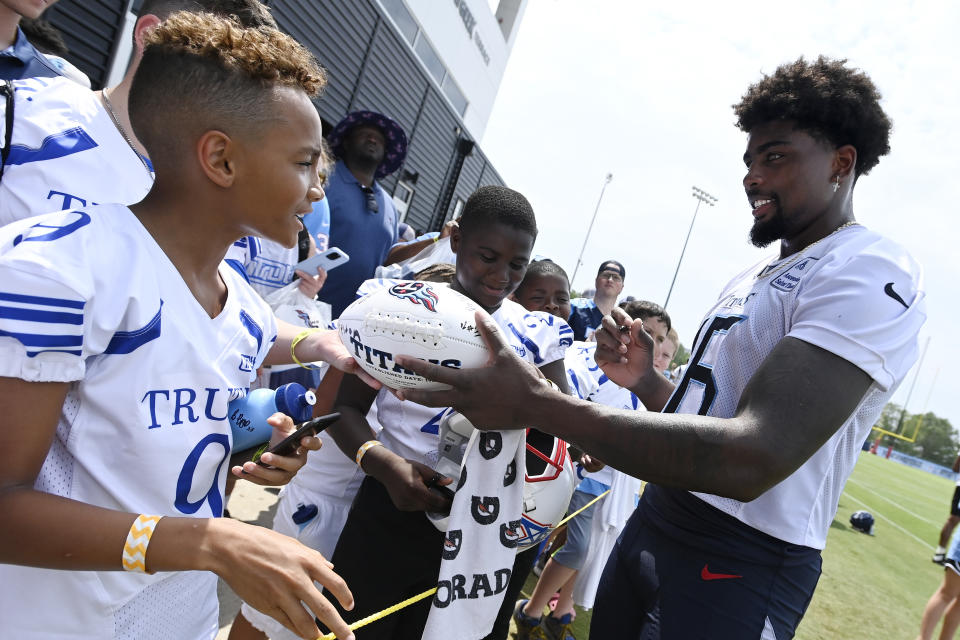 Tennessee Titans wide receiver Treylon Burks (16) signs autographs for fans after practice at the NFL football team's training camp, Saturday, July 29, 2023, in Nashville, Tenn. (AP Photo/Mark Zaleski)