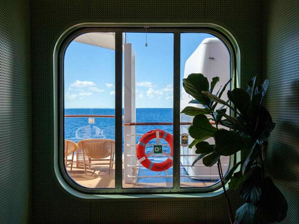 a window looking out onto the walkway and ocean