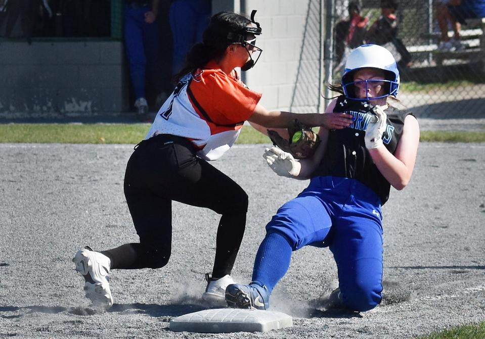 Blue Hill's Jayden Craft is safe back to third under the tag of Diman's Nya Martinez.