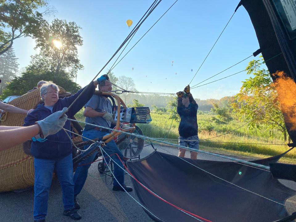 Battle Creek balloon pilot Pat Rolfe burns propane to inflate his Seal balloon with help from crew members at Fort Custer Recreational Area in Augusta Saturday, July 2, 2022.