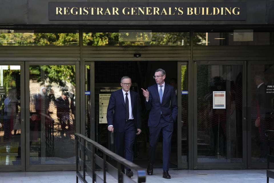 Australian Prime Minister Anthony Albanese, left, and New South Wales Premier Dominic Perrottet, walk out of a building that will be demolished in a proposed public square named in honor of Queen Elizabeth II in Sydney, Australia, Wednesday, Sept. 14, 2022. Albanese announced a square in honor of the late queen and that he will be taking to London the leaders of Papua New Guinea, the Solomon Islands and Tuvalu with him along with 10 ordinary people from each country to attend the funeral of Queen Elizabeth II. (AP Photo/Rick Rycroft)