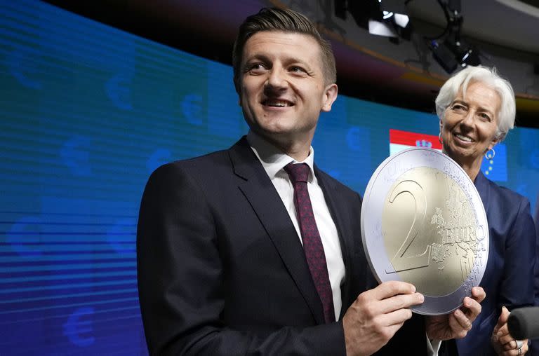 El ministro de Finanzas croata, Zdravko Maric, con una moneda de euro de cartón junto a la presidenta del Banco Central Europeo, Christine Lagarde