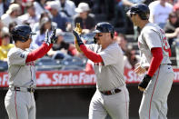 Boston Red Sox's Masataka Yoshida, left, greets Reese McGuire, center, with Triston Casas, right, after McGuire hit a three-run home run against the Los Angeles Angels during the sixth inning of a baseball game in Anaheim, Calif., Sunday, April 7, 2024. (AP Photo/Alex Gallardo)