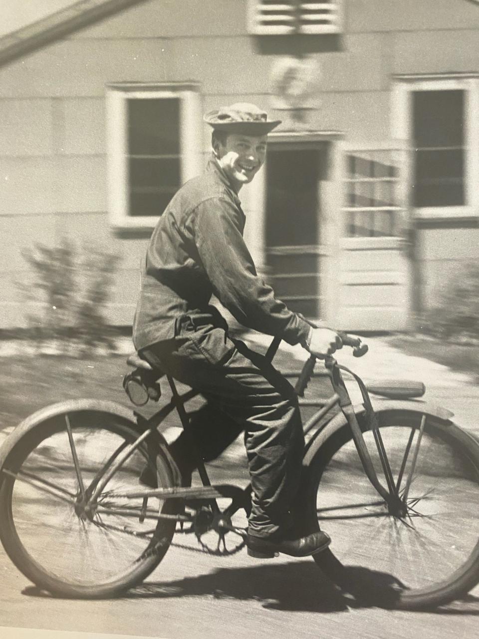 Libert Bozzelli, in uniform, riding a bike during World War II.