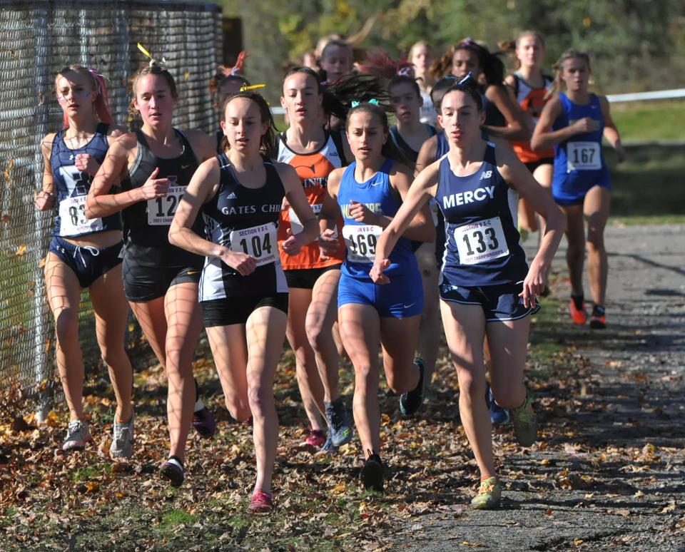 Gates Chili senior Kyra Pellegrino (center, bib number 104) and others during the Section V Class A Girls Cross County Championships inside Letchworth State Park.