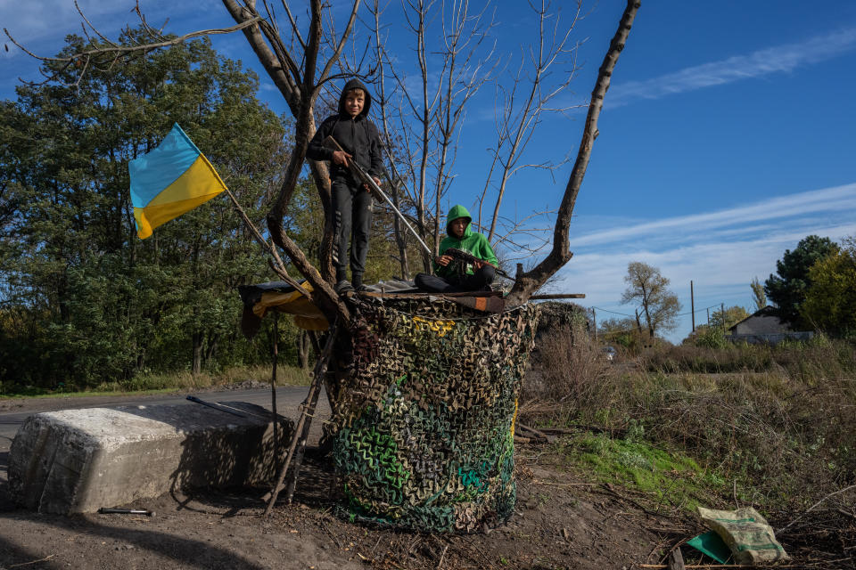 DUBOVE, UKRAINE - OCTOBER 19: Boys hold toy rifles as they pause while playing by the roadside on October 19, 2022 in Dubove, Kharkiv oblast, Ukraine. Russia's president Vladimir Putin today imposed martial law on the four Ukrainian regions occupied by Russian forces as large numbers of civilians were being moved out of the Kherson area ahead of a Ukrainian offensive. (Photo by Carl Court/Getty Images)