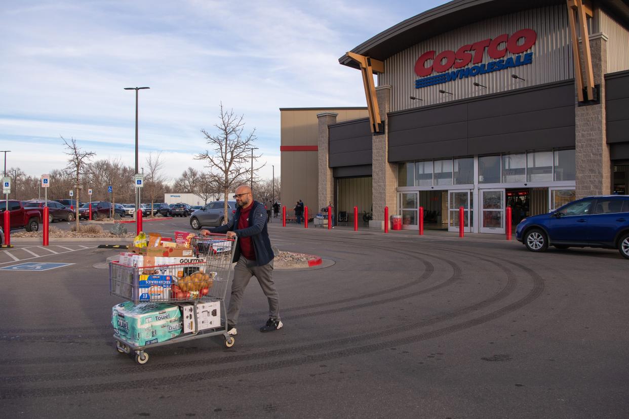 A man exits Costco with a full grocery cart Friday, Jan. 13, 2023, in Timnath, Colorado.