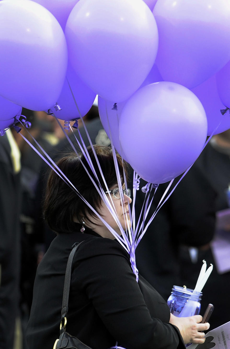 A woman carries balloons during a vigil for Maren Sanchez at Jonathan Law High School, Monday, April 28, 2014, in Milford, Conn. Sanchez was fatally stabbed inside the school on Friday hours before her junior prom. (AP Photo/Jessica Hill)