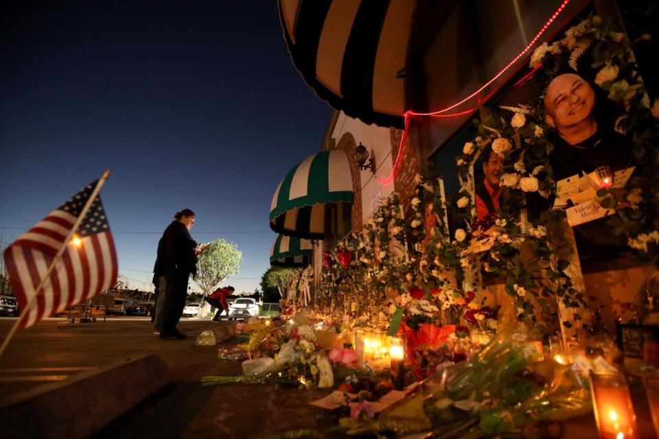 A woman prays at the memorial for 11 people who died in the Monterey Park mass shooting.