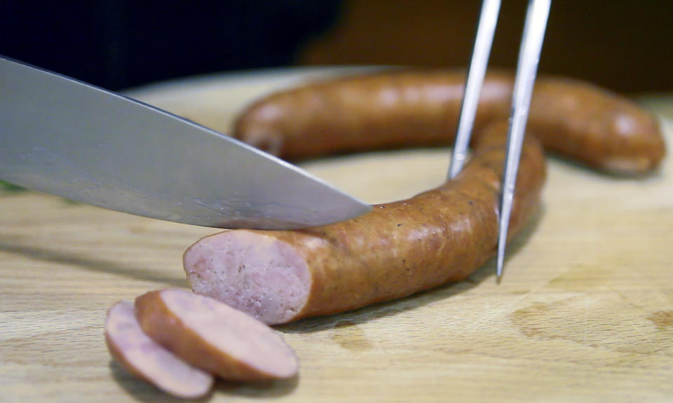 In this photo taken Thursday, April 19, 2012, a pair of "Kranjska" sausages are cut up in a restaurant in Ljubljana, Slovenia. Slovenia and Austria are gearing up for a diplomatic battle over a delicacy both countries claim their own, a spicy pork sausage. (AP Photo/Darko Bandic)