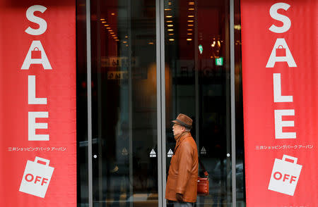 FILE PHOTO: A man stands in front of an entrance of a shopping mall nearby the Bank of Japan building in Tokyo, Japan January 15, 2018. REUTERS/Kim Kyung-Hoon/File Photo