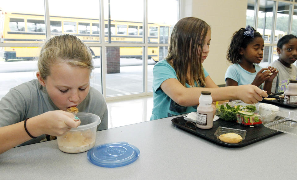 Rebekah Mizelle, 10, left, eats her cereal lunch as her friend and classmate Erin Bynum eats her school lunch Wednesday, Sept. 12, 2012 at Eastside Elementary School in Clinton, Miss. Students have several options for a nutritious lunch including bringing their own. (AP Photo/Rogelio V. Solis)