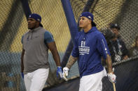 Los Angeles Dodgers' Manny Machado, right, enters the batting cage as Yasiel Puig watches his hit during baseball practice Wednesday, Oct. 3, 2018, in Los Angeles for Thursday's Game 1 of the team's National League Division Series against the Atlanta Braves. (AP Photo/Jae C. Hong)