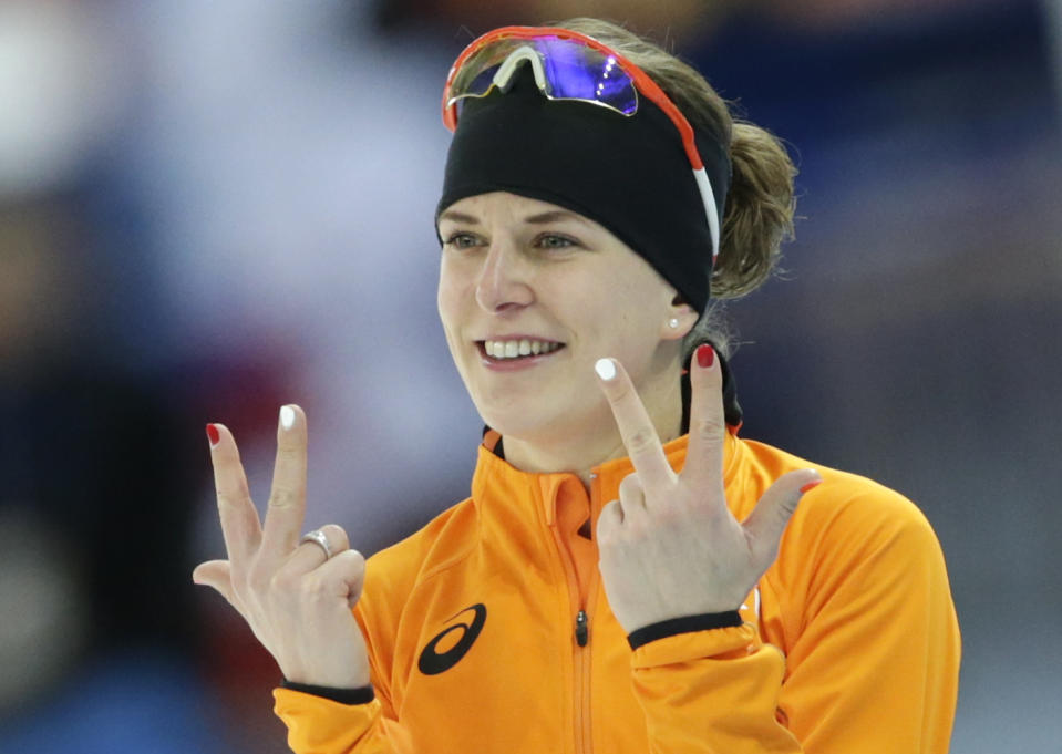 Ireen Wust of the Netherlands flashes three fingers in each hand, indicating her third olympic gold medal, after winning gold in the women's 3,000-meter speedskating race at the Adler Arena Skating Center during the 2014 Winter Olympics, Sunday, Feb. 9, 2014, in Sochi, Russia. (AP Photo/Matt Dunham)