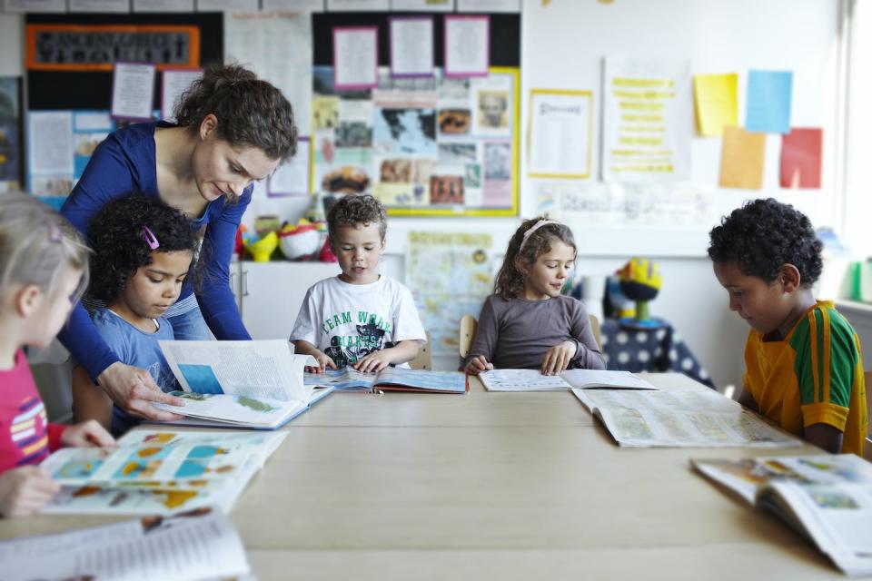 Racially integrated schools are associated with building cross-racial relationships that teach children how to work effectively with others. <a href="https://www.gettyimages.com/detail/photo/teacher-looking-in-books-with-children-royalty-free-image/143560401?phrase=school+classroom+elementary&adppopup=true" rel="nofollow noopener" target="_blank" data-ylk="slk:Klaus Vedfelt/DigitalVision via Getty Images;elm:context_link;itc:0;sec:content-canvas" class="link ">Klaus Vedfelt/DigitalVision via Getty Images</a>