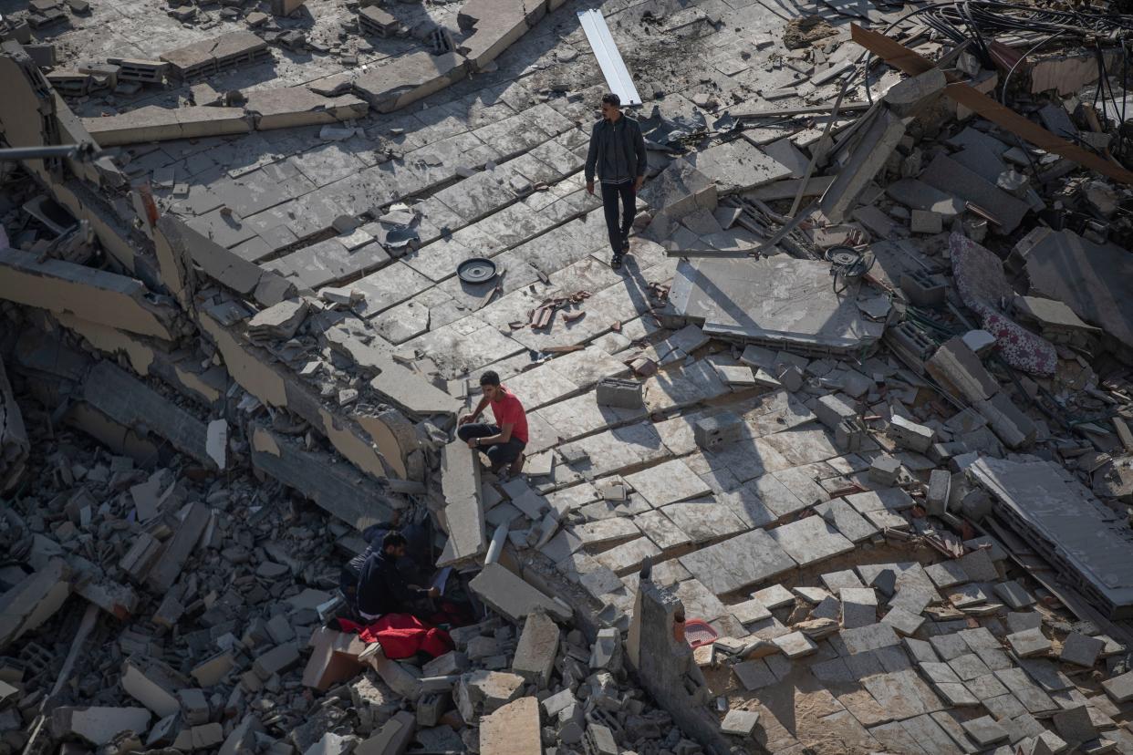 Palestinians inspect the rubble of their destroyed home after being hit by Israeli airstrikes in the town of Beit Lahiya northern Gaza Strip, Thursday, May 13, 2021.