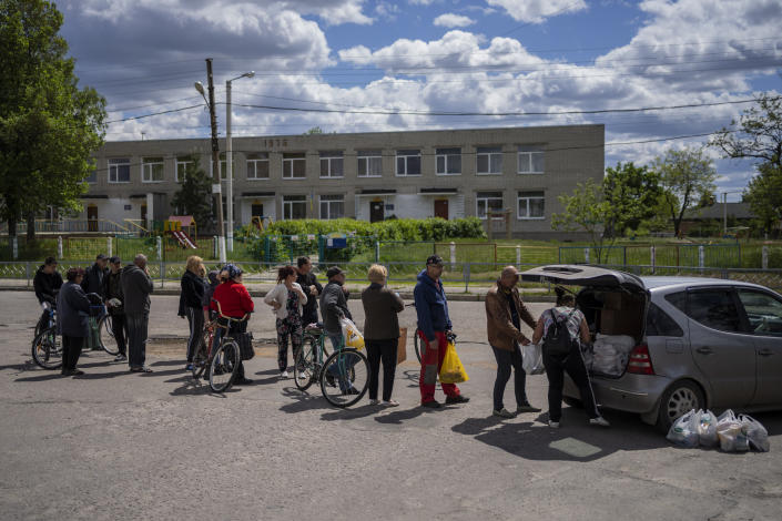Residents queue to receive food donations in Kharkiv, Ukraine, Monday, May 16, 2022. (AP Photo/Bernat Armangue)