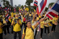 Supporters of the Thai the monarchy display images of King Maha Vajiralongkorn, Queen Suthida and late King Bhumibol Adulyadej and wave the national flag during a rally at Lumphini park in central Bangkok, Thailand, Tuesday, Oct. 27, 2020. Hundreds of royalists gathered to oppose pro-democracy protesters' demands that the prime minister resign, constitution be revised and the monarchy be reformed in accordance with democratic principles. (AP Photo/Gemunu Amarasinghe)