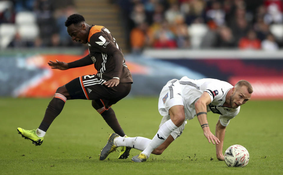 Swansea City's Mike van der Hoorn, right, and Brentford's Moses Odubajo during their English FA Cup fifth round soccer match at the Liberty Stadium in Swansea, England, Sunday Feb. 17, 2019. (Nick Potts/PA via AP)