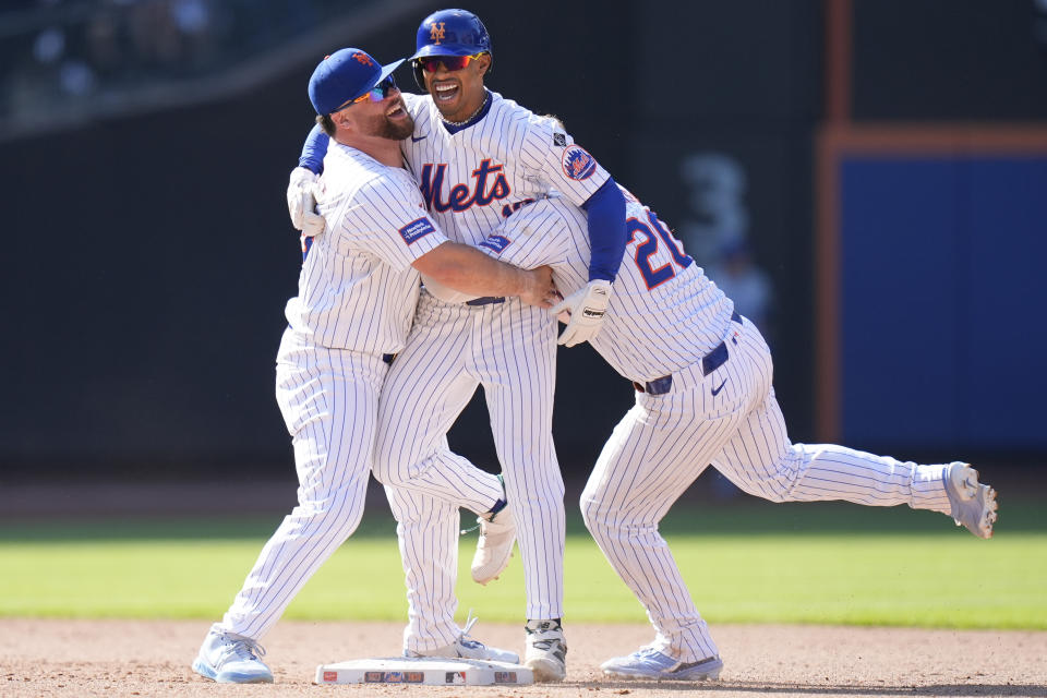 New York Mets' Francisco Lindor, center, celebrates with teammates DJ Stewart, left, and Pete Alonso after hitting a walk-off two-run double during the 11th inning of a baseball game against the Chicago Cubs at Citi Field, Thursday, May 2, 2024, in New York. The Mets defeated the Cubs 7-6 in 11 innings. (AP Photo/Seth Wenig)