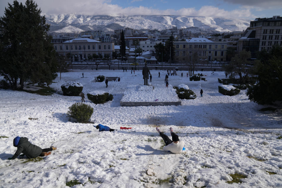 People play with the snow in Athens, on Tuesday, Jan. 25, 2022. A snowstorm of rare severity disrupted road and air traffic Monday in the Greek capital of Athens and neighboring Turkey's largest city of Istanbul, while most of Greece, including — unusually — several Aegean islands, and much of Turkey were blanketed by snow. (AP Photo/Thanassis Stavrakis)