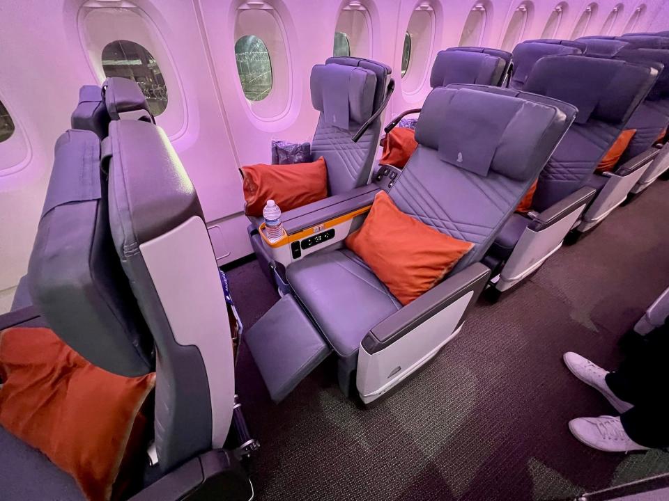 Singapore Airlines premium economy seat fully reclined with legrest out.