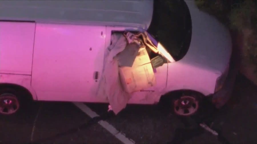 The suspect stuffed a large cardboard box and blanket into the shattered van window to block officers' non-lethal rounds. (KTLA)