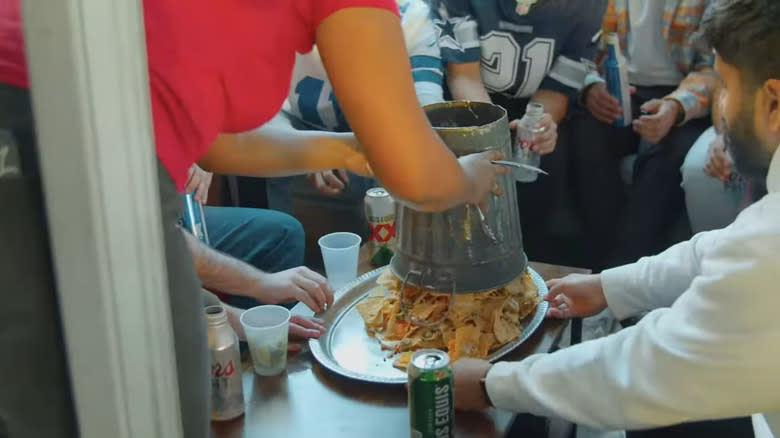 server pouring trashcan nachos