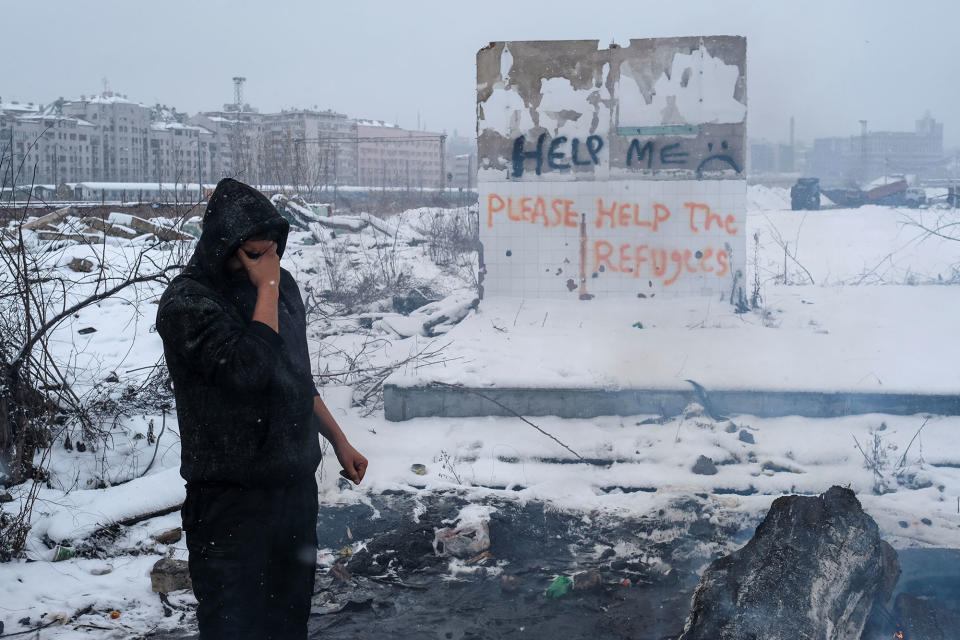 A migrant stands by a fire in Belgrade