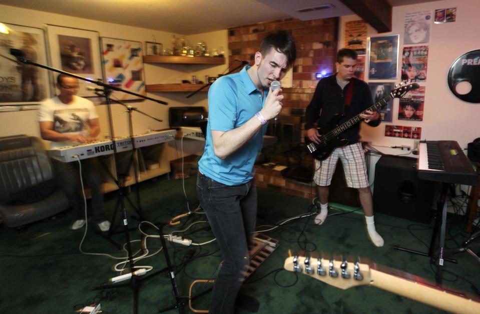 Michael Henrichsen, center, sings during a rehearsal of his 80's music tribute band, "Nite Wave," Oct. 3, 2012, in Lynnwood, Wash. Henrichsen created a website and enlisted friends and celebrities around the world in a two-year effort to convince rock star Billy Idol to come play a concert on Oct. 26, 2012 at a Seattle music venue to raise money for charity and celebrate Henrichsen's birthday. (AP Photo/Ted S. Warren)