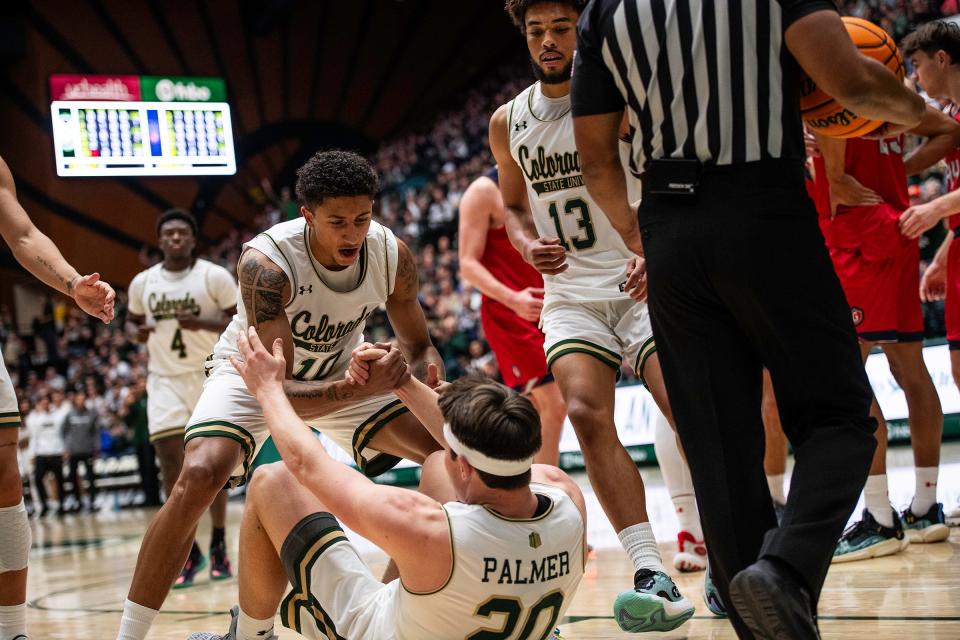 Colorado State's Nique Clifford (10) helps Joe Palmer up after a foul during a game against St. Mary's at Moby Arena in Fort Collins on Dec. 9.