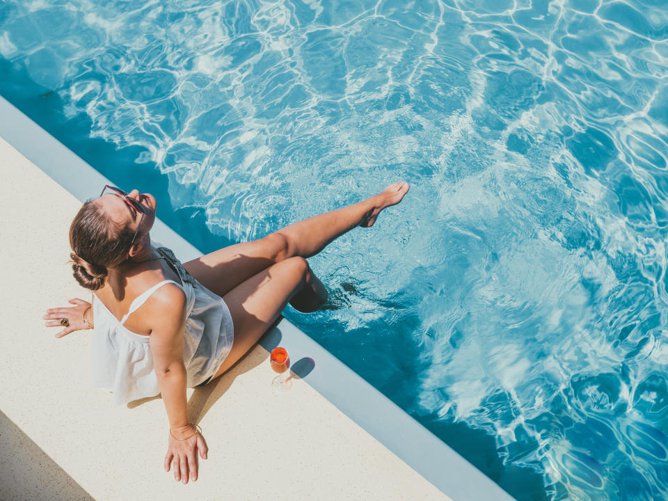 a woman sitting on the edge of a pool